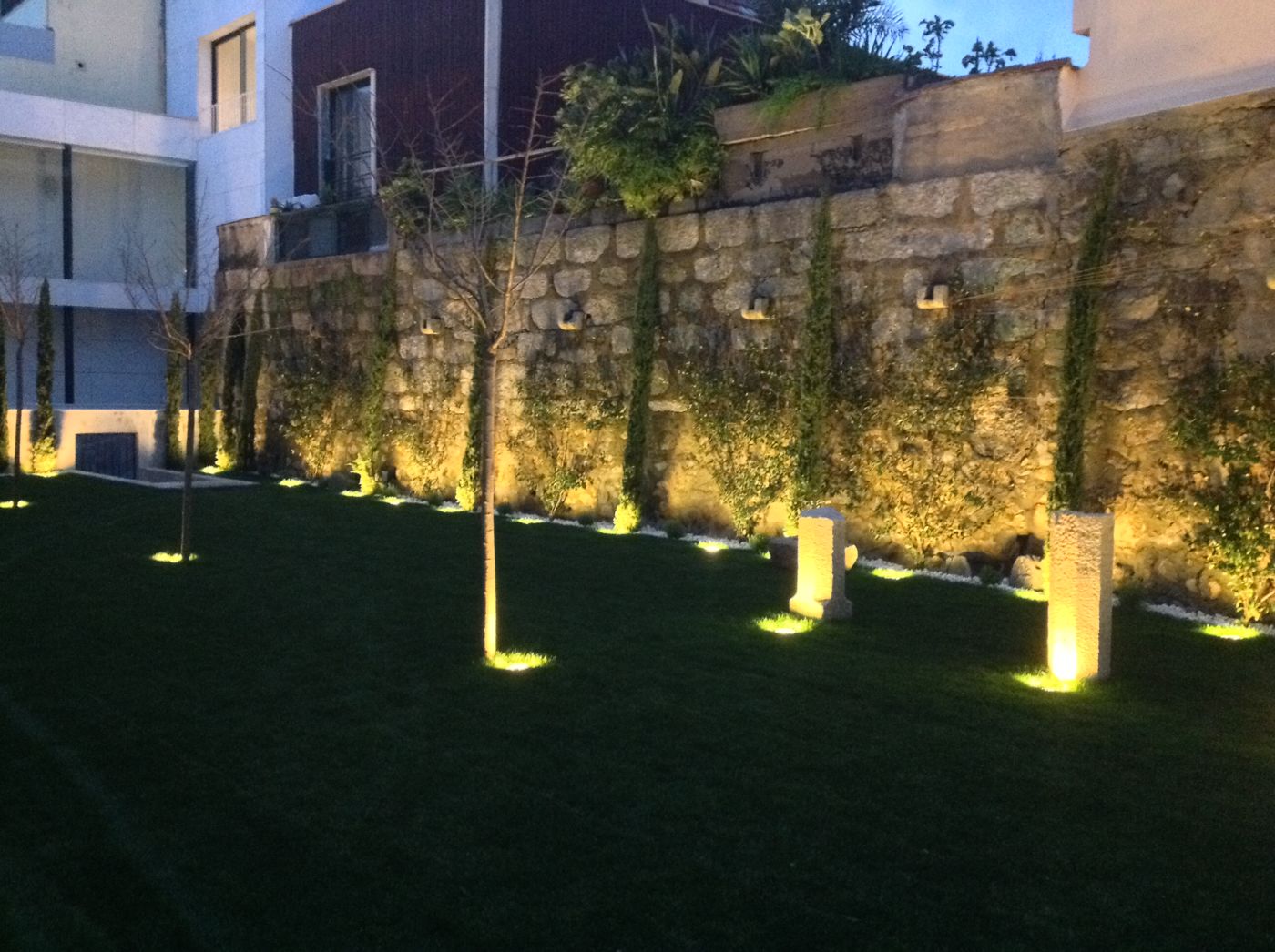 Jardim com iluminação de chão e de muro